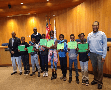Group of 7 children holding recognition certificates