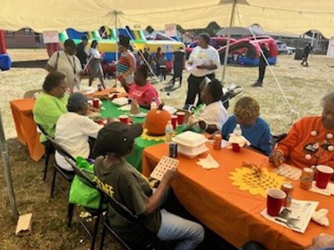 People sitting at tables under a tent.