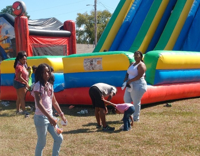 People standing by a large inflatable slide.