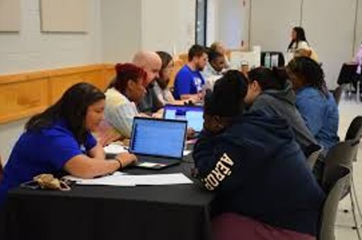 Students sitting at a table looking at computers.
