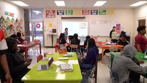 Students sitting in a classroom listening to the teacher.