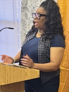 Ashely Reynolds speaking at a podium.