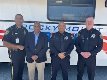 Four police officers stand and smile for a picture.