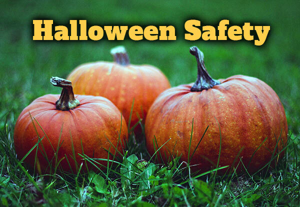 Halloween Safety. Three pumpkins sitting in the grass.